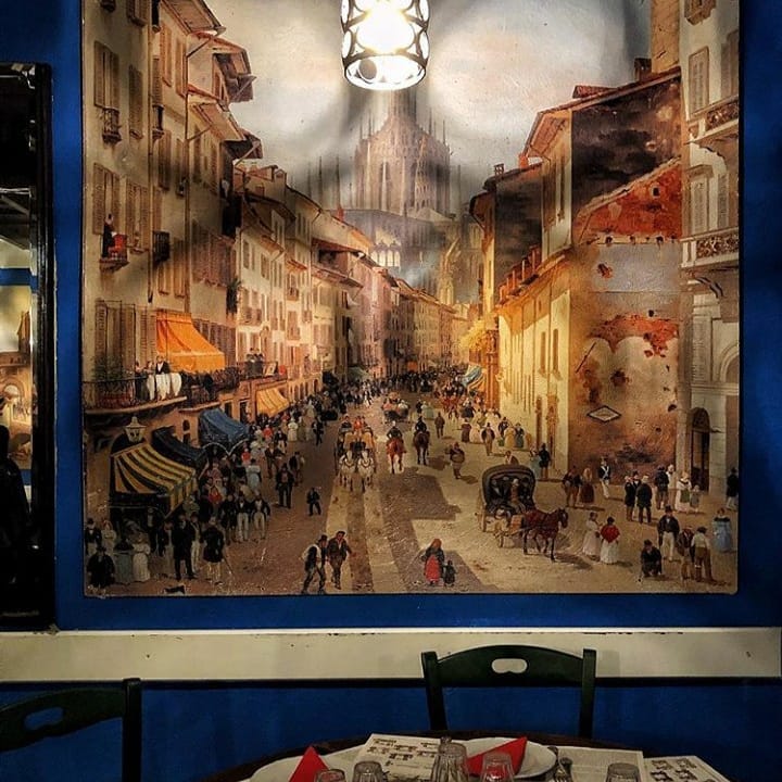 La sala dell'Osteria Alla Grande, con un grande dipinto della vecchia Milano alle pareti